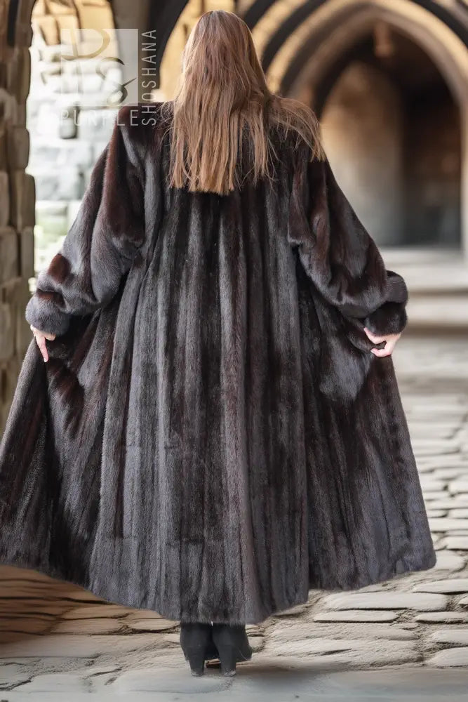 Back view of a long black mink fur coat with full sleeves and straight hem