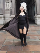 Dark brown mink fur coat with open tuxedo front and flared hem over a dress