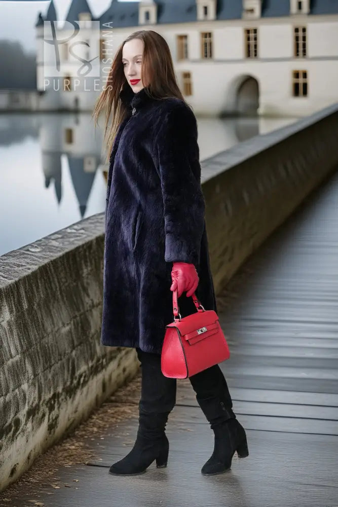 "Midnight Iris" navy sheared beaver coat in side profile, flared hem, red cuffs