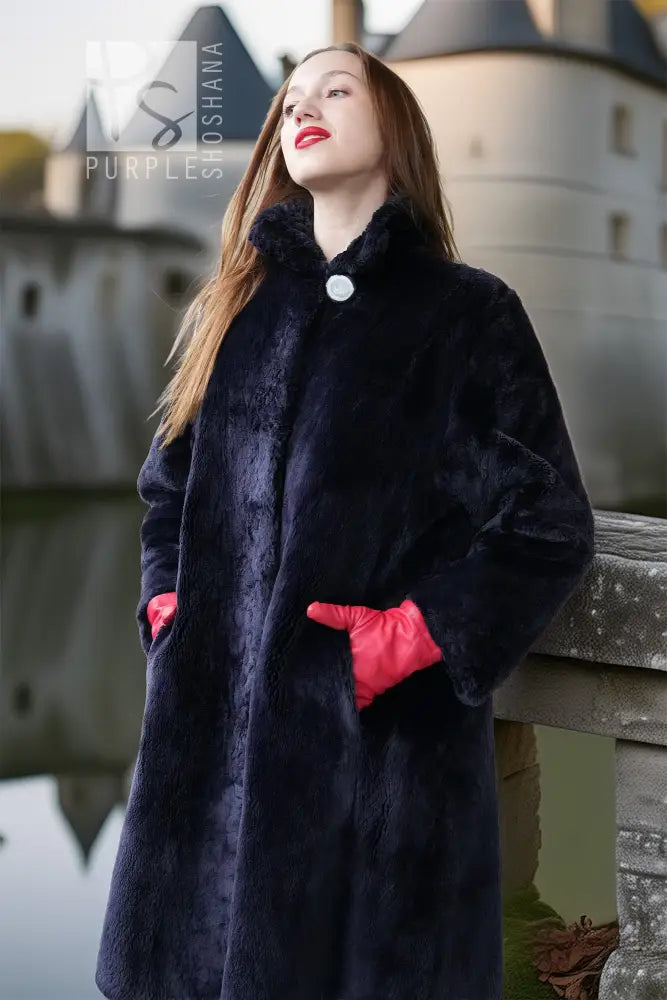 Close-up of "Midnight Iris" sheared beaver coat, navy, stand collar and red inner cuffs