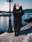 Black mink coat with open front and long sleeves, full length by waterfront