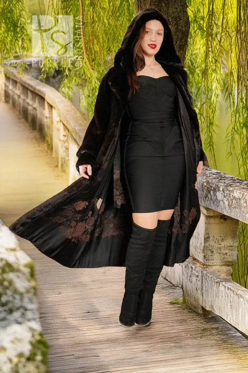 Black hooded mink coat with open front; model standing in full length, hood up.