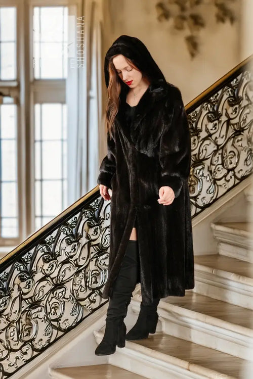 Black hooded mink coat, long length, button front, worn with dark boots