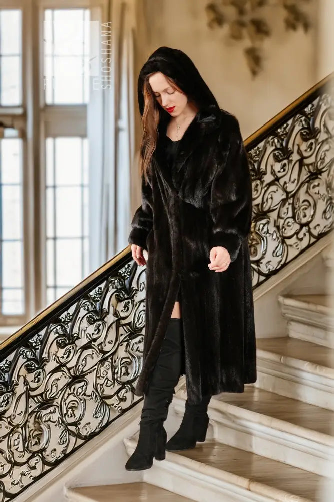 Black hooded mink coat, long length, button front, worn with dark boots