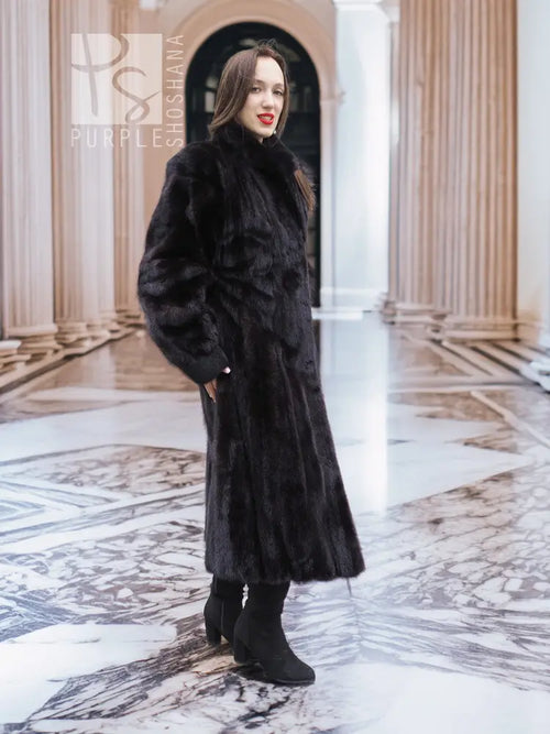 Long black mink fur coat with high collar and full sleeves, button-front style.