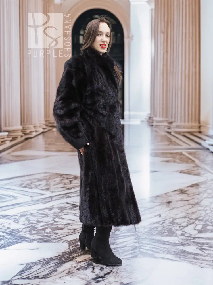 Long black mink fur coat with high collar and full sleeves, button-front style.