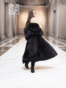 Black mink coat with fur hood and draped collar, side front view