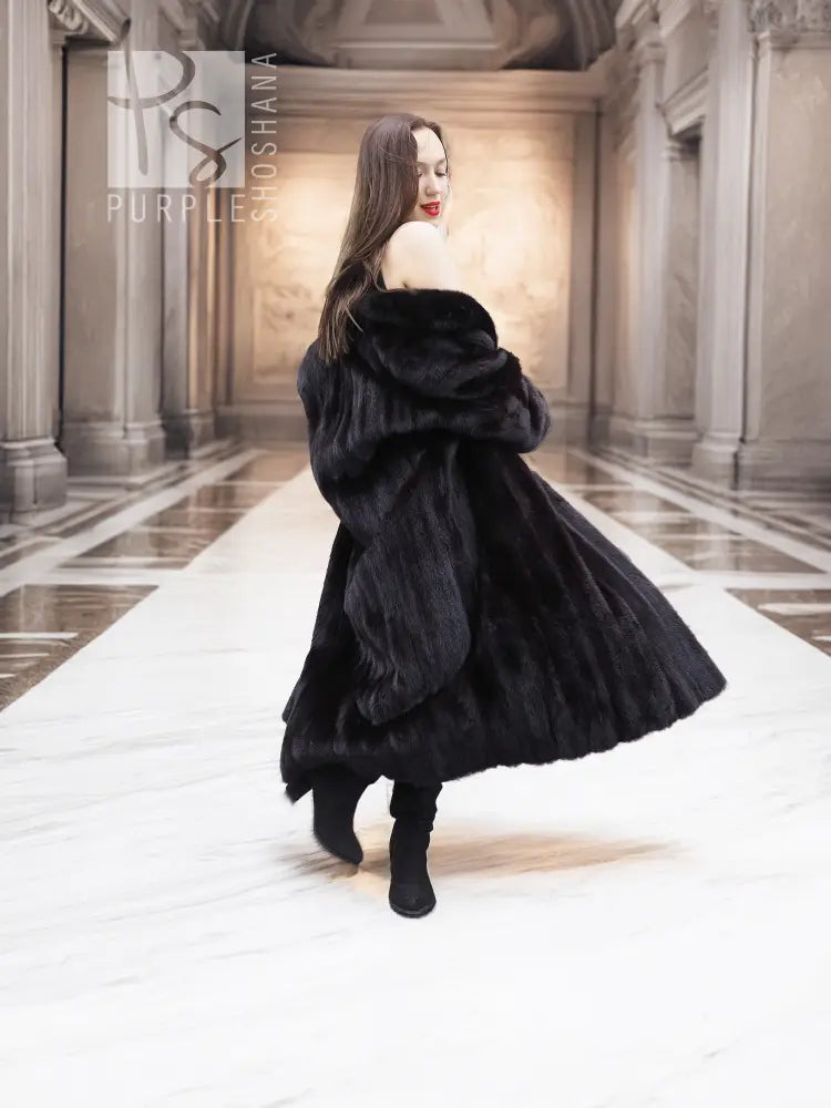 Black mink coat with fur hood and draped collar, side front view