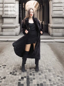 Black mink fur coat worn over black dress, long hem and plush fur collar.
