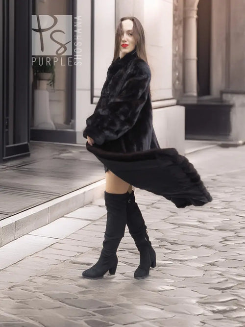 Black mink fur coat with high neckline, knee-length hem, and long draped sleeves.