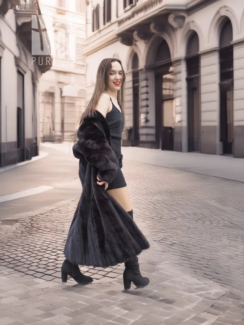 Black mink fur coat with off-shoulder sleeves, walking look over black dress