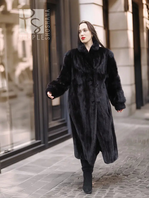 Black mink coat with hood and wide fur collar, front walking pose