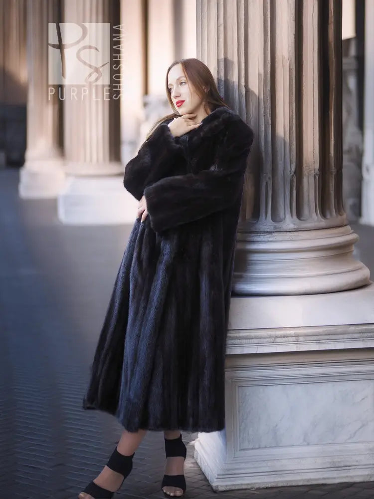 Black mink coat, long mid-calf length with rounded fur collar and draped sleeves.