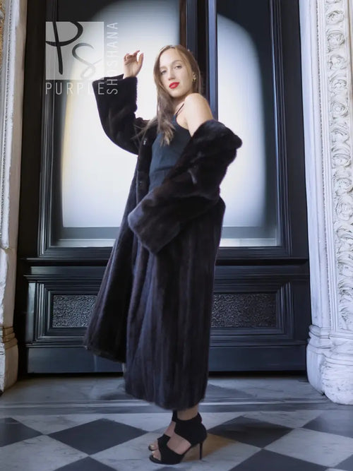 Black mink coat, full-length with belt-like waist and open front, standing pose