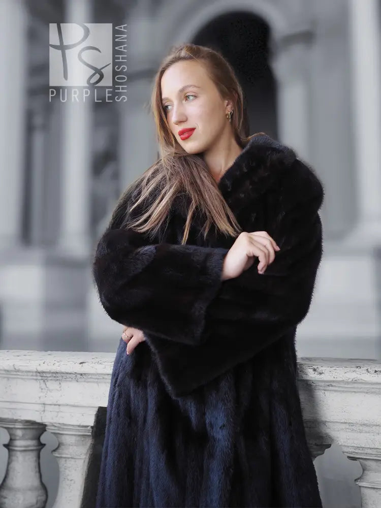 Black mink coat close-up, plush fur texture and wide cuffs, arms crossed