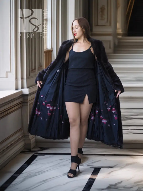 Black mink coat, long mid-calf length with open front and floral-lined inner hem.