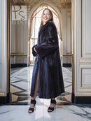 Black mink coat, long mid-calf length with voluminous sleeves and dark fur collar.