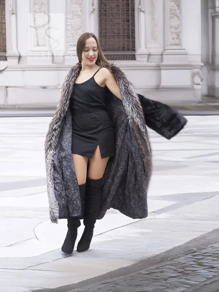 Black mink coat draped over a dress, with silver fox fur collar