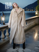 Cream fur coat with pointed lapels, long length, and relaxed fit over boots.