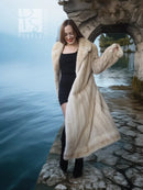 Light cream long fur coat over black dress, featuring a large pointed collar.