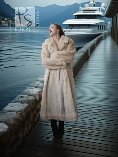 Cream long fur coat with thick collar and button closure, styled with tall black boots.