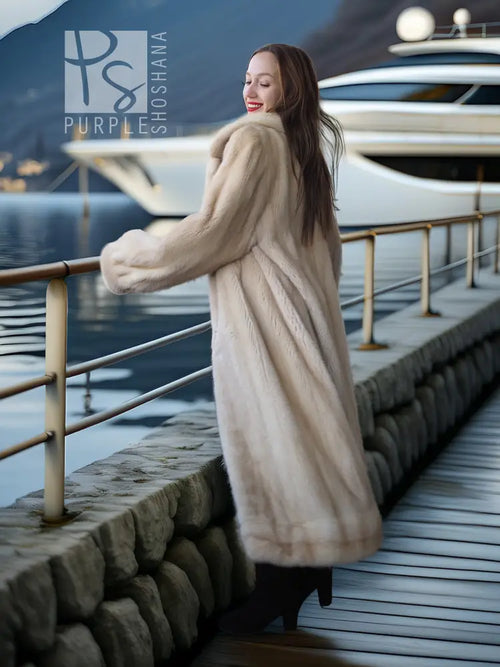 Light cream fur coat with pointed collar and long sleeves, open front over dark outfit.