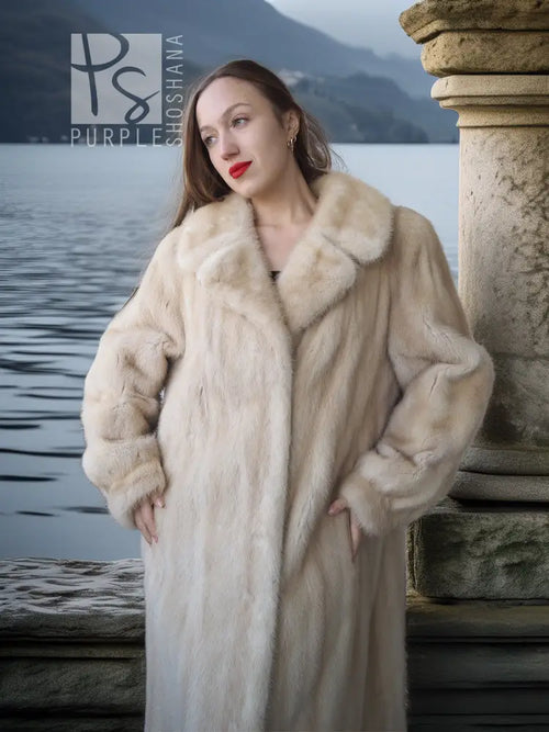 Cream faux fur coat with thick collar and button-front, shown from mid-length up.
