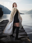Cream fur coat draped over shoulders, open front showing a fitted black dress.