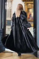 Black mink full-length coat with high collar and wide sleeves; back view.
