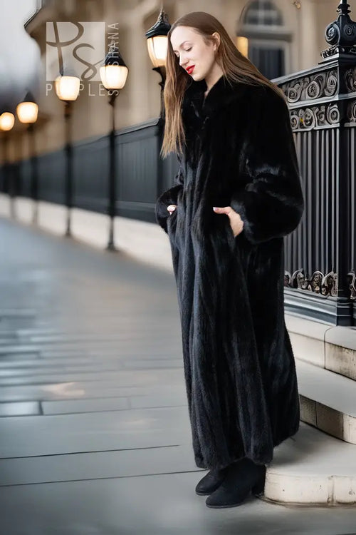 Black mink full-length coat with high collar and button front; three-quarter side view.