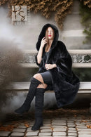Black hooded mink coat with plush fur and open front, worn with knee-high boots.