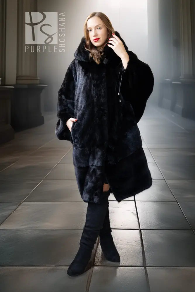 Black hooded mink coat worn over dark pants and boots, front view