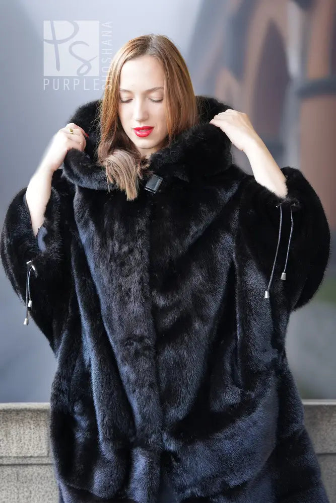 Black hooded mink coat close-up with large collar and drawstring details