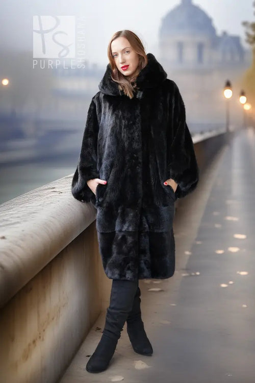 Black hooded mink coat with textured fur, standing pose on a walkway