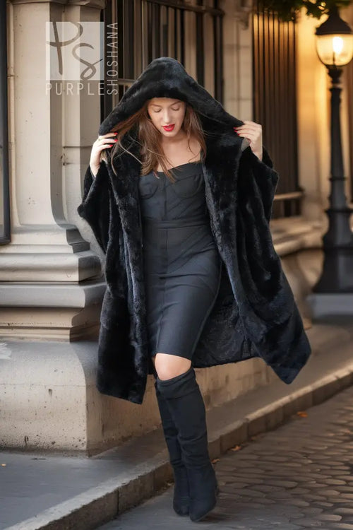 Black hooded mink coat with layered fur look and open front, styled with knee boots.