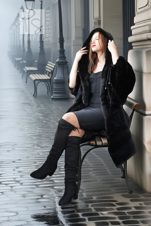 Black hooded mink coat with open front, full fur sleeves, styled with tall black boots.
