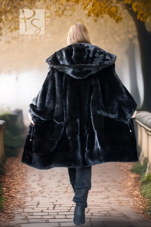 Black hooded mink coat from behind, full skirt flare over dark leggings