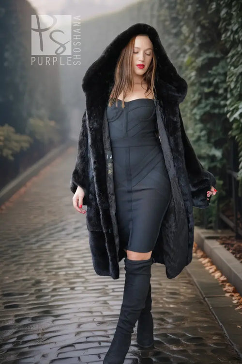 Black hooded mink coat, full-length fur sleeves and open front over a fitted black dress.