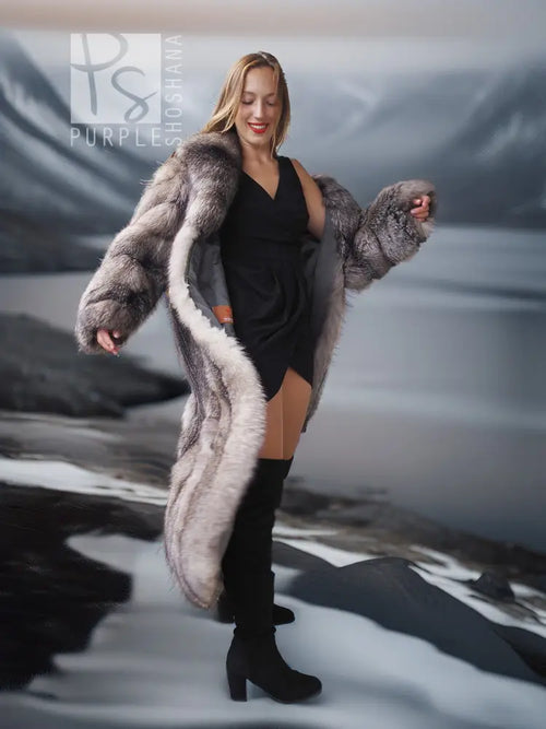 Fox fur shawl-collar coat with long gray fur, front view over black dress and boots