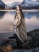 Long fur coat in striped tan and brown, side profile, open front and flowing hem.