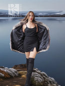 Platinum silver fox fur jacket with open front over a black satin dress and tall boots