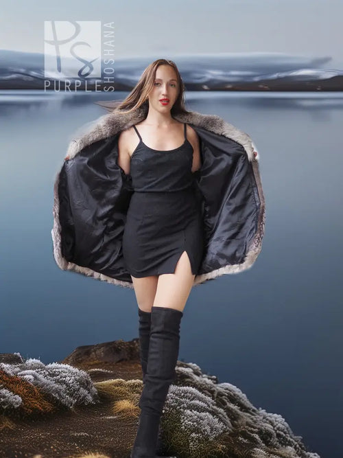 Platinum silver fox fur jacket with open front over a black satin dress and tall boots