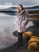 Platinum silver fox fur jacket with long sleeves over black dress and tall boots