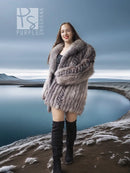 Platinum silver fox fur jacket with thick fur texture over a black dress and boots