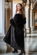 Black fur coat with off-shoulder wide fur sleeves, standing side view