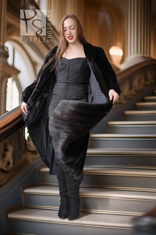 Black fur coat with wide cuffs and button front, styled with fitted outfit