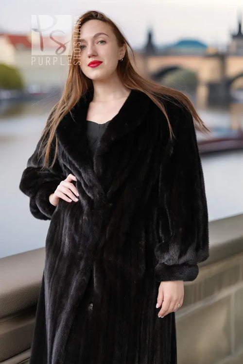 Black fur coat with button-front, long sleeves, knee-length, side view.