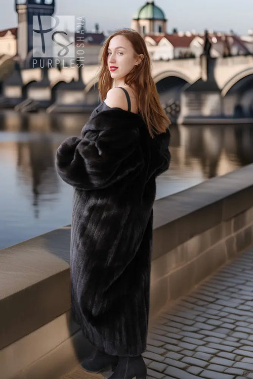 Black mink coat with full skirt and wide cuffs, side view with boots.