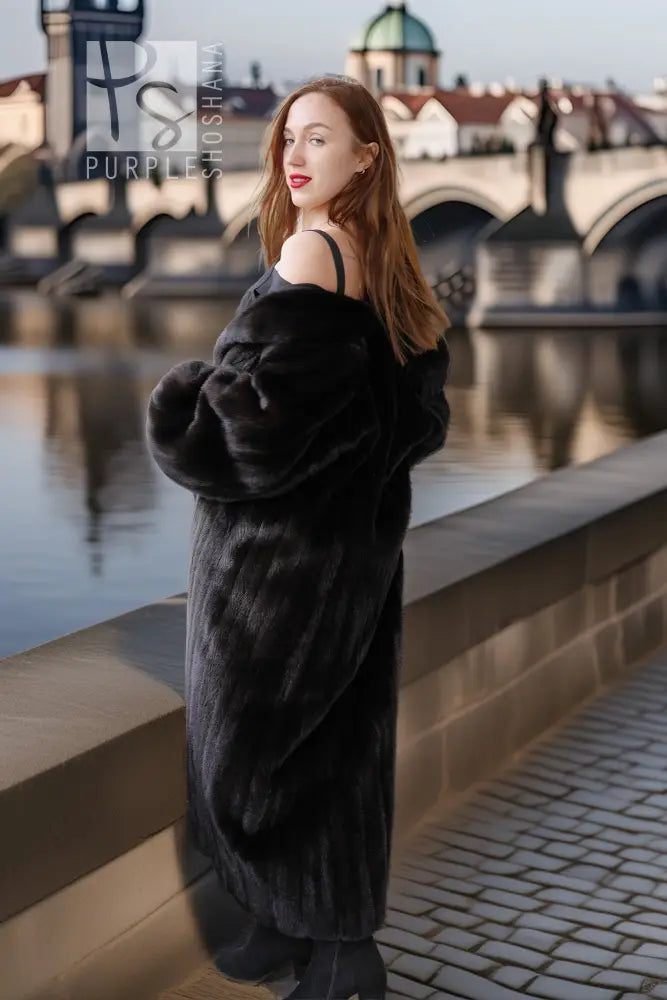 Black mink coat with full skirt and wide cuffs, side view with boots.