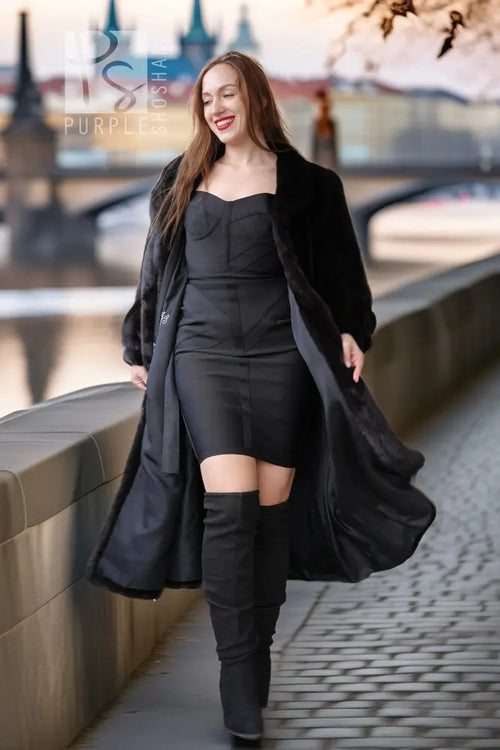 Black fur coat with button-front, wide skirt hem, long sleeves, standing pose.